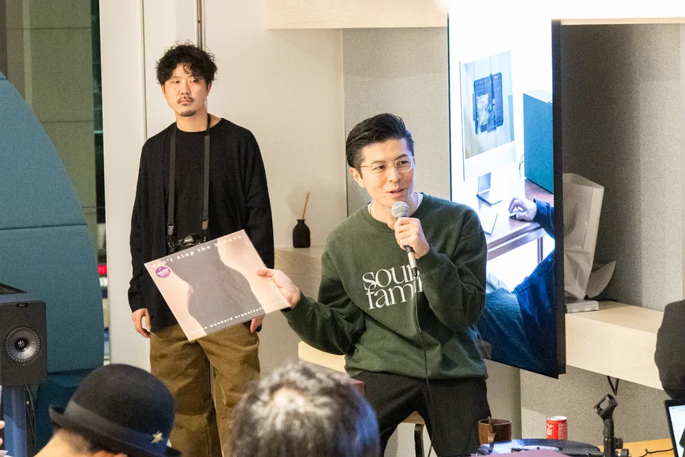 レコードを手に、マイクで話す出演者